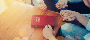 Close Up Of People Group Holding Hand And Pray Together Over A